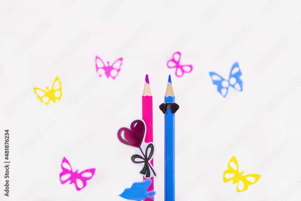 colored pencils. a couple in love. blue and pink pencil among butterflies