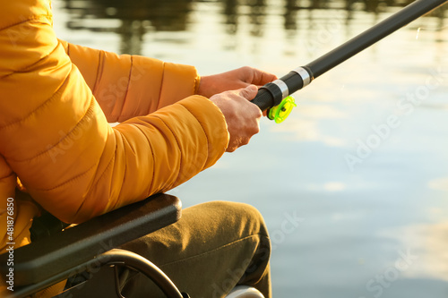 Man in wheelchair fishing on river