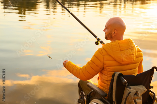 Man in wheelchair fishing on river