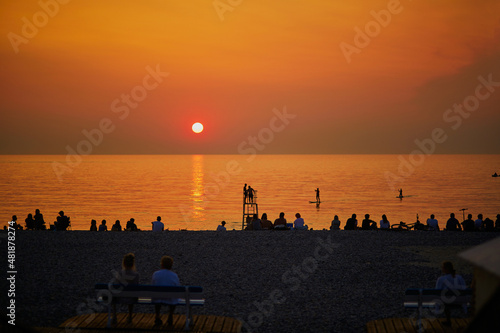 People enjoying sunset on the beach of Mers-les-Bains, France