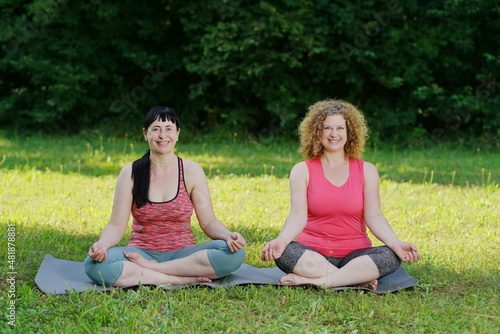2 Frauen machen Yoga im Park, Schneidersitz © Pro-pictures