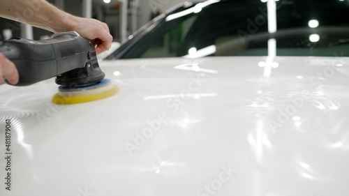 Polishing hood with wax. The master polishes the car.
