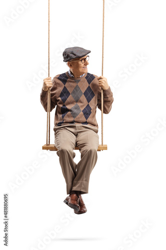 Elderly man sitting on a wooden swing and looking to the side