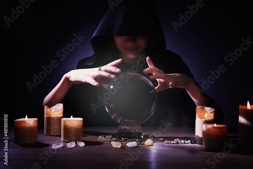 Obraz na płótnie Soothsayer using crystal ball to predict future at table in darkness