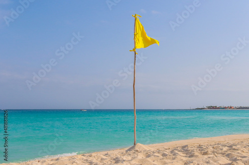 Yellow flag during a beautiful day at the beach in Cancun. 