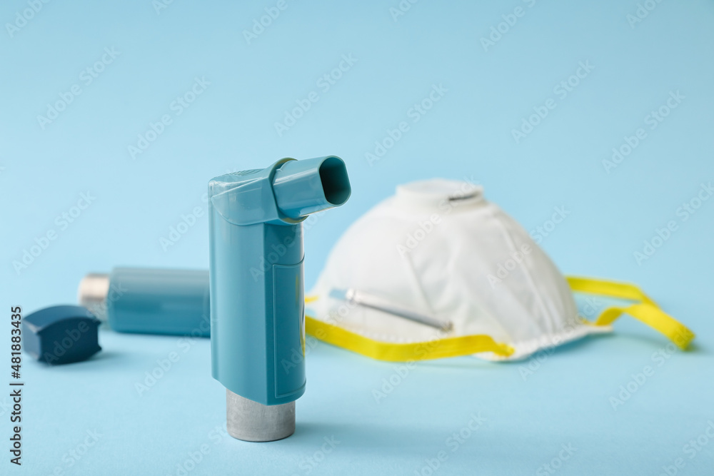 Asthma inhaler and mask on blue background, closeup Asthma inhaler and mask on blue background, closeup
