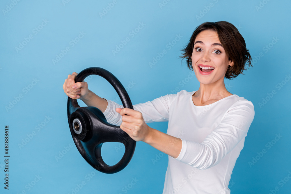 Profile side photo of adorable cheerful lady riding extreme fast traveling adventure isolated on blue color background Profile side photo of adorable cheerful lady riding extreme fast traveling adventure isolated on blue color background