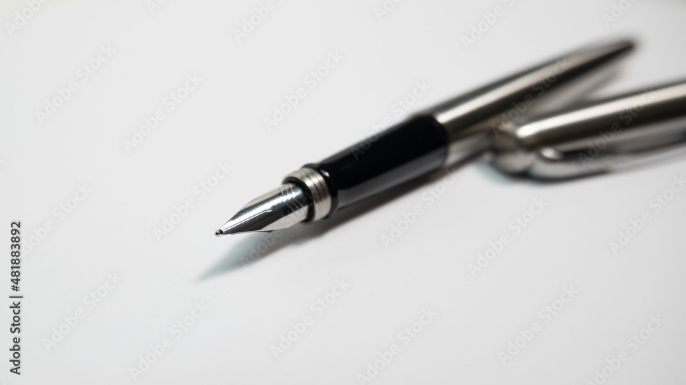Fountain pen on a sheet of white paper. Close up, shallow depth of field. Fountain pen on a sheet of white paper. Close up, shallow depth of field.