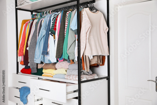 Rack with stylish women's clothes in room. Fast fashion © New Africa