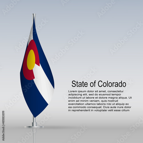 Flag of State of Colorado (USA) hanging on a flagpole stands on the table