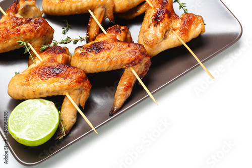 Plate with grilled chicken wings skewers on white background, closeup