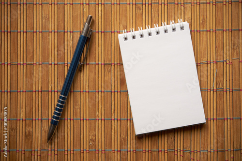 notatnik i długopis na bambusowej podkładce 