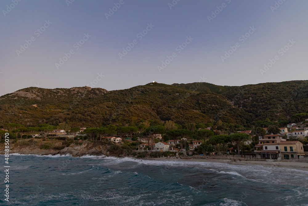 Coast and sea near Sant'Andrea on the island of Elba in Italy with blue sky in summer at dusk