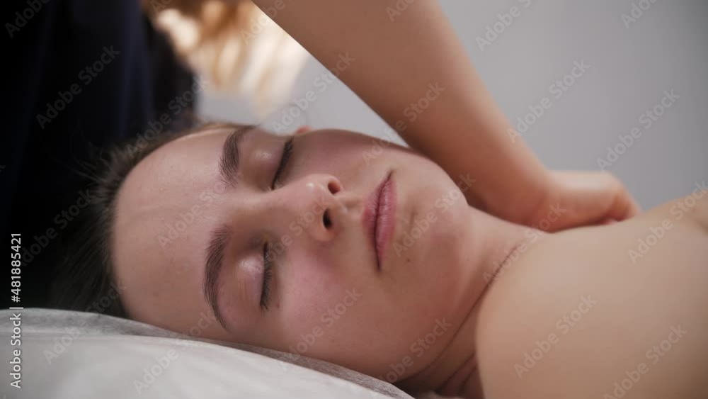 Massage session - the massagist massaging neck and shoulders of her female client Massage session - the massagist massaging neck and shoulders of her female client