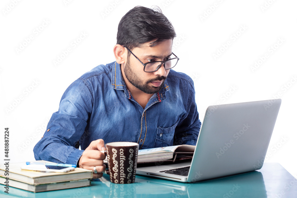 man working on laptop while drinking coffee in cold morning time. man working on laptop while drinking coffee in cold morning time.