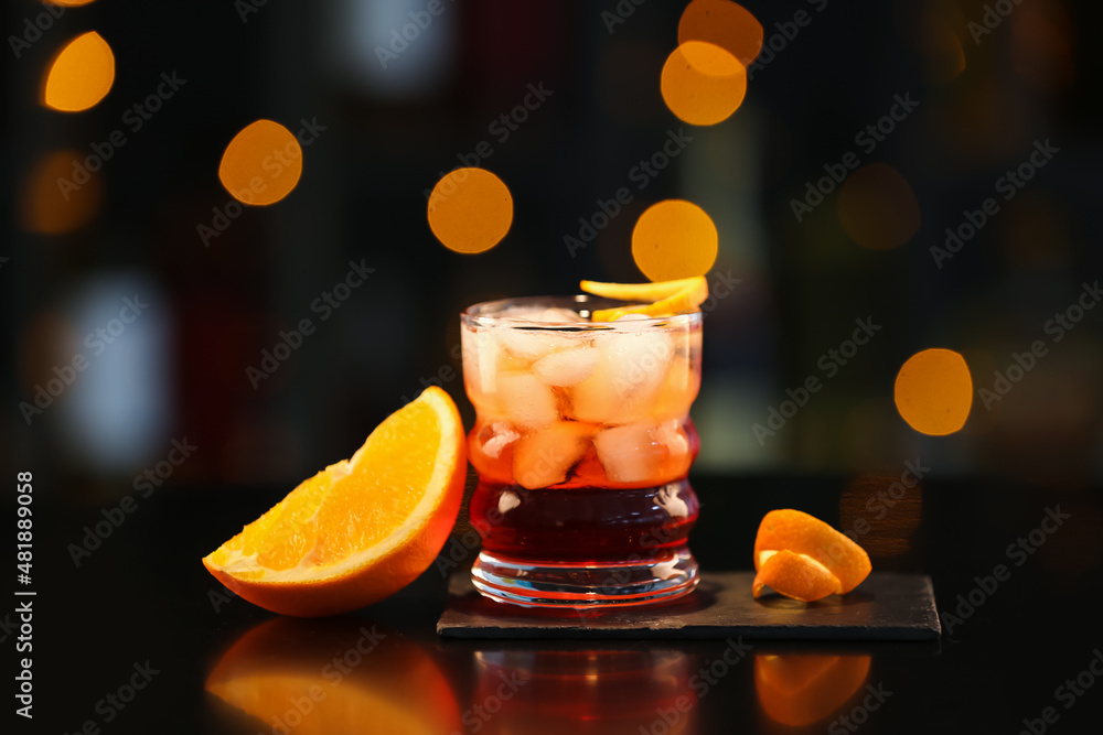Glass of tasty Negroni cocktail on table against blurred background Glass of tasty Negroni cocktail on table against blurred background