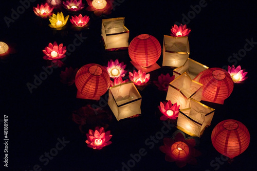 Floating paper lanterns on the water at night photo