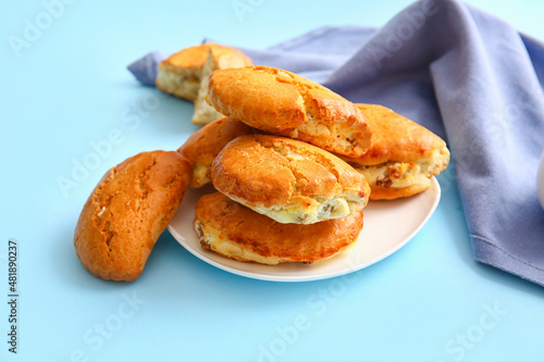 Plate of tasty sochniki with cottage cheese on blue background