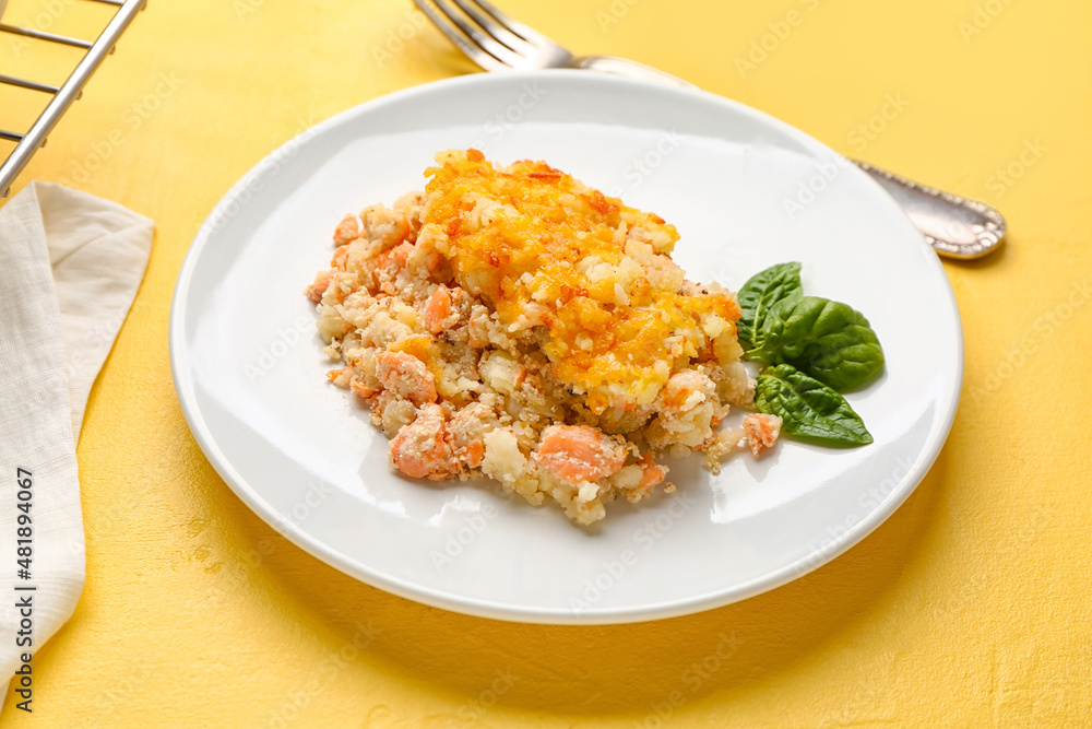 Plate with tasty English fish pie on yellow background Plate with tasty English fish pie on yellow background
