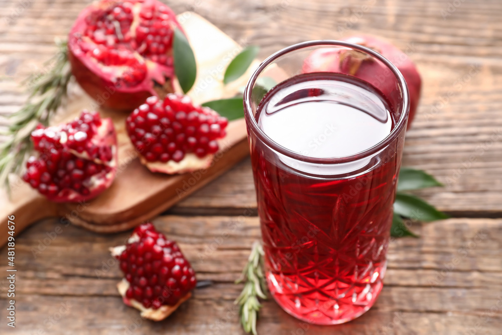 Glass of delicious pomegranate juice on wooden background Glass of delicious pomegranate juice on wooden background