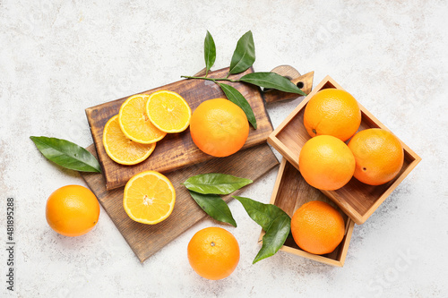 Wooden boards with fresh juicy oranges on light background © Pixel-Shot