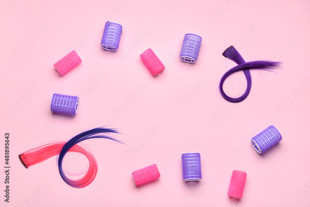 Frame made of hair strands and curlers on pink background