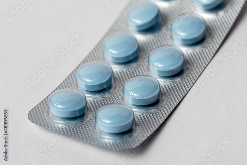 Blue pills in a blister close-up. Vitamins for health in a blister. Vitamins to strengthen the immune system. Medicines for treatment and prevention.