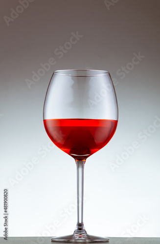 copa de vino tinto sobre un fondo blanco

