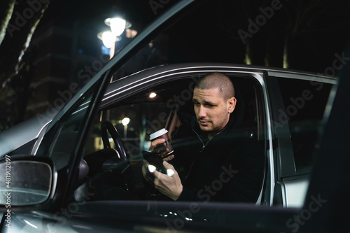 A man arguing with car service on video call outside at night