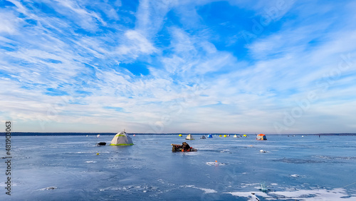winter fishing, ice fishermen catch fish in winter tents