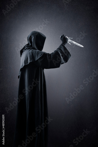 Hooded man with dagger in the dark © Jakub Krechowicz