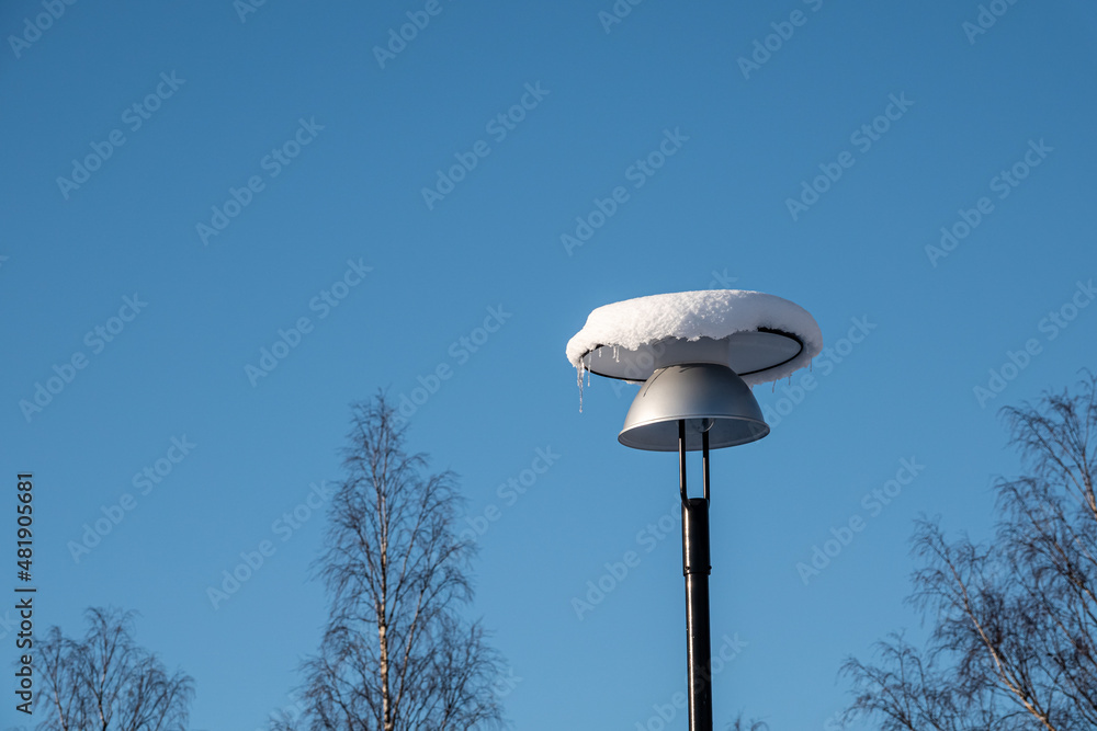 Low angle view of snow covered lamp against blue sky Low angle view of snow covered lamp against blue sky