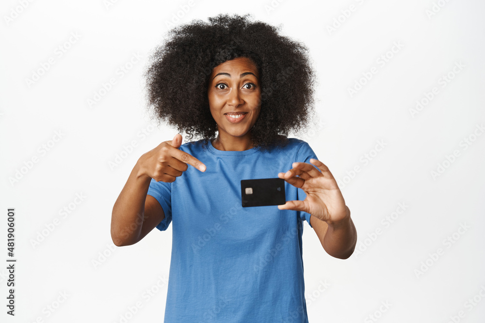Portrait of african american woman showing credit card, recommending new bank, shopping discounts with contactless payment, white background Portrait of african american woman showing credit card, recommending new bank, shopping discounts with contactless payment, white background