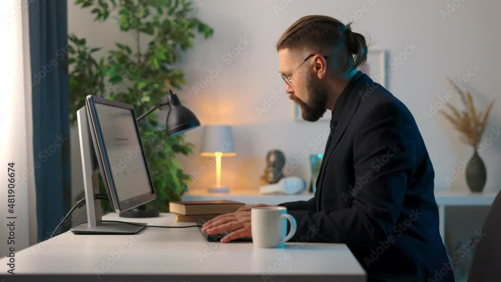 Focused mature man in black suit and eyeglasses working on modern computer while sitting at home office. Concept of people, technology and freelance. Focused mature man in black suit and eyeglasses working on modern computer while sitting at home office. Concept of people, technology and freelance.