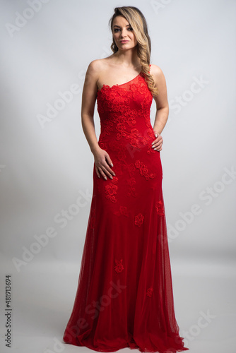 beautiful young blond woman in dress on white studio background