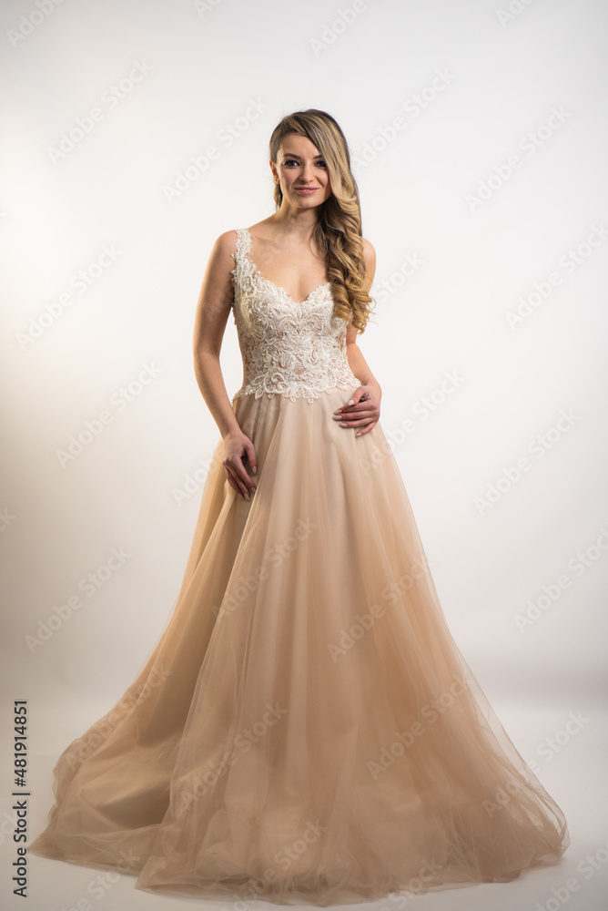 beautiful young blond woman in dress on white studio background