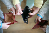 Three people holding an empty wallet in their hands
