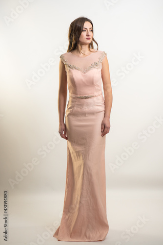 Full length tall slim luxurious elegant lush brown hair green eyes woman in evening neckline classic dress standing with manicure hands mannerly in side in front of on white studio background