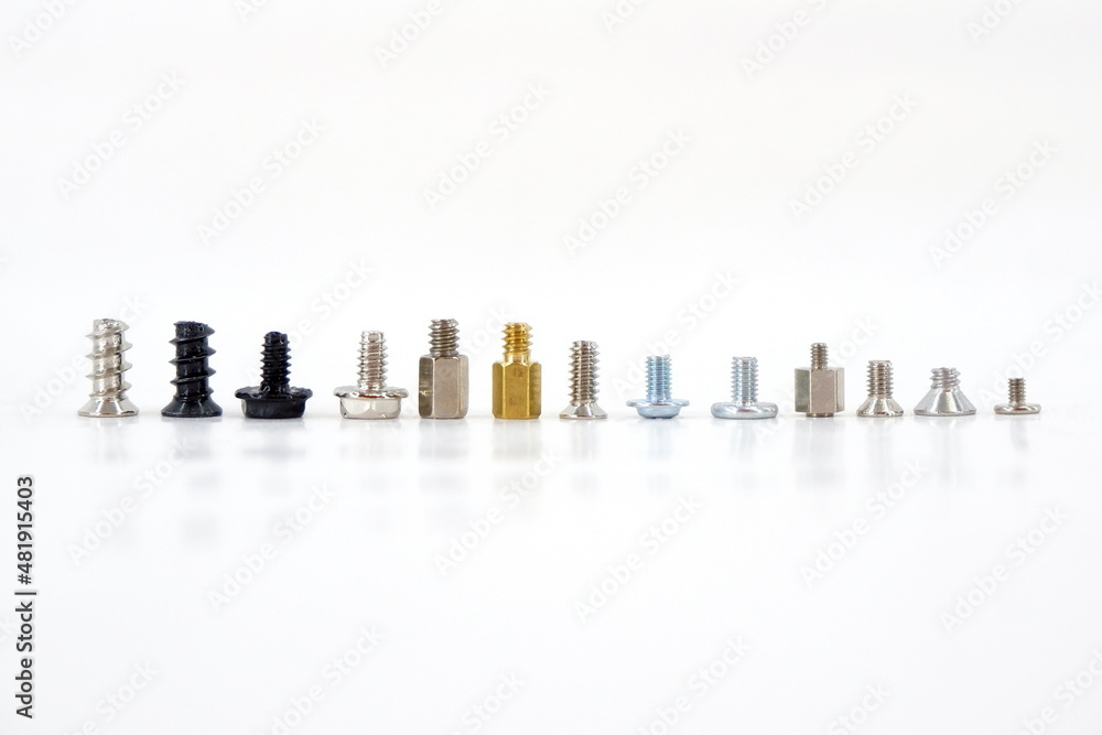 A set of fasteners of components in a PC. There are many screws for the computer case lined up in a row. All kinds of Screws for PC assembly. On an isolated white background. A set of fasteners of components in a PC. There are many screws for the computer case lined up in a row. All kinds of Screws for PC assembly. On an isolated white background.
