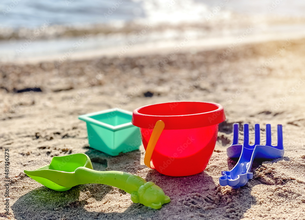 Toys shovel, rake and bucket for childrens sandbox on the beach. Childrens toys Toys shovel, rake and bucket for childrens sandbox on the beach. Childrens toys