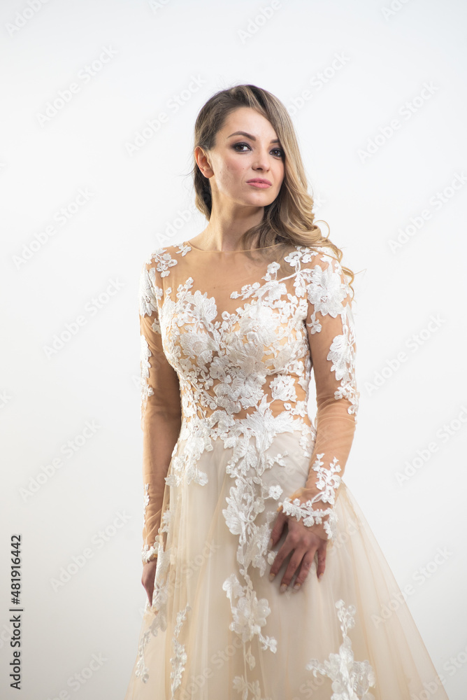 Beautiful attractive bride in wedding dress with long full skirt, white background Beautiful attractive bride in wedding dress with long full skirt, white background