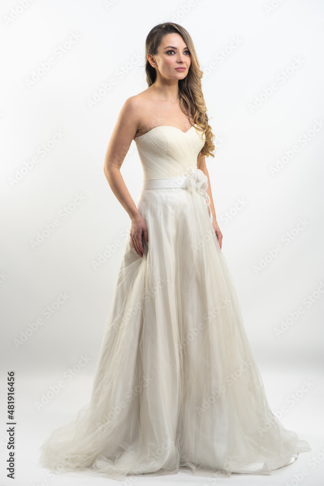 beautiful young blond woman in dress on white studio background