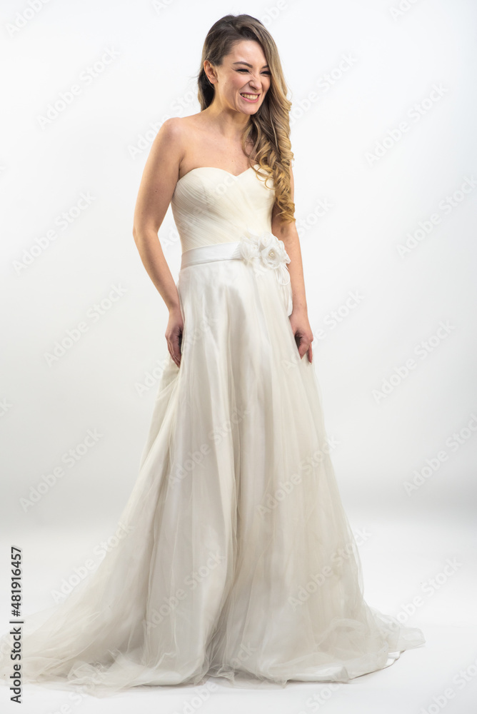 Beautiful bride with fashion hairstyle and make-up wearing wedding dress on white background Beautiful bride with fashion hairstyle and make-up wearing wedding dress on white background