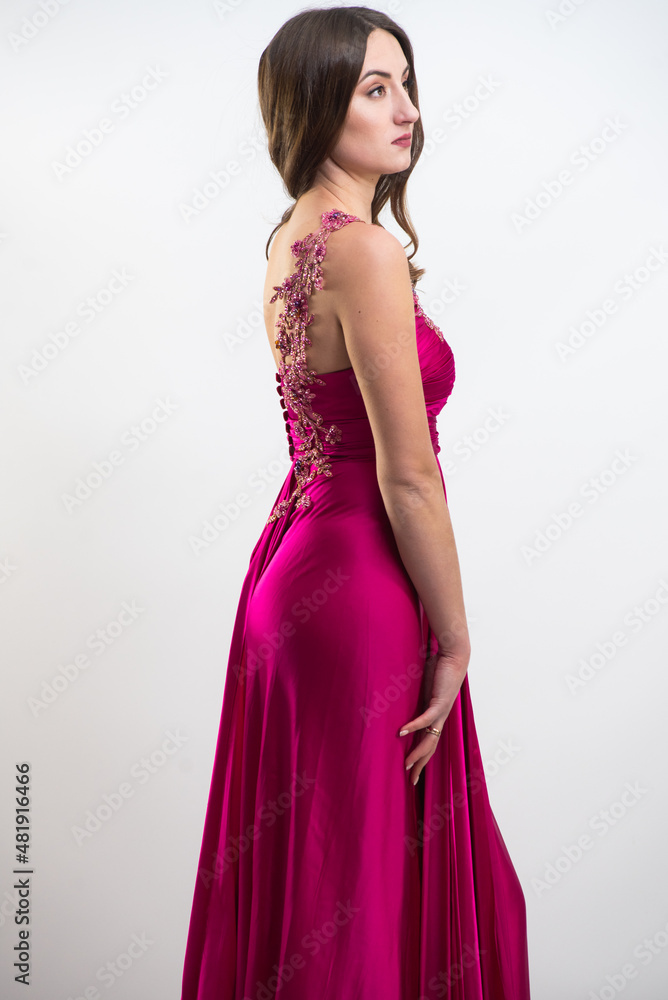 Full body portrait of gorgeous young brunette woman dressed in exquisite nude ball gown with lace top. Attractive female model in elegant strapless dress posing against white background. Full body portrait of gorgeous young brunette woman dressed in exquisite nude ball gown with lace top. Attractive female model in elegant strapless dress posing against white background.