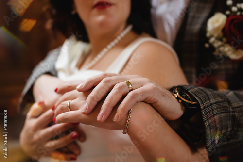 bride and groom holding hands with wadding rings
