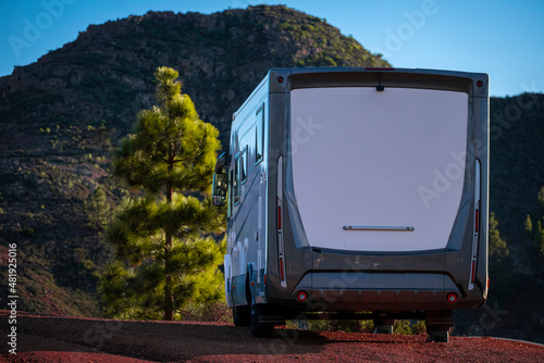 Camper van summer holiday vacation and free tourism lifestyle. Big camping car motorhome parked off road and enjoying mountains ad nature. Family tourists with recreational vehicle