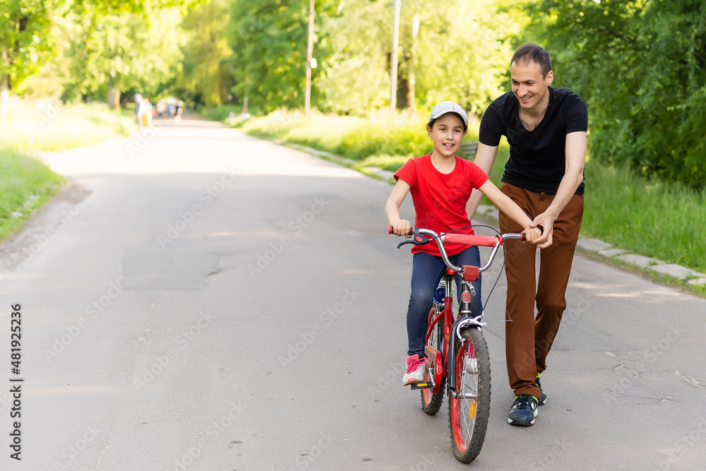 loving father teaching daughter to ride bike