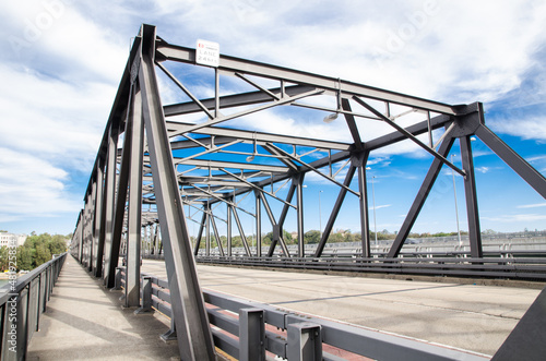 Steel bridge structure with Cycleway alongside it on beautiful cloudy, blue sky day. © arliftatoz2205
