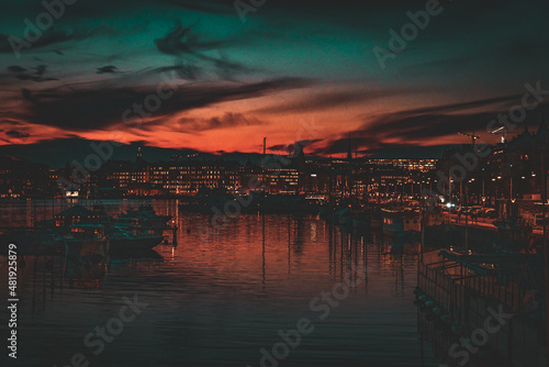 Picturesque Orange and Blue Sunset over Harbour with Boats and Twinkling City Lights © David