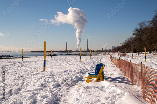 A plume of white  vapour rises from the stacks of a natural gas fired generating station on the shore of Lake Ontario shot on a cold sunny winter's day.  